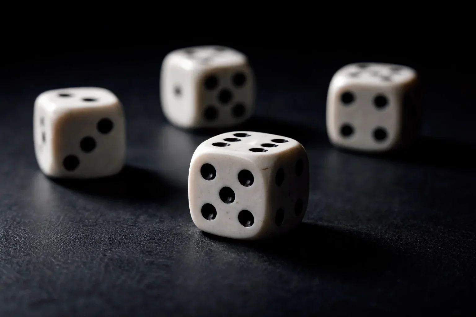 Würfel auf dunkler Oberfläche als Symbol für Wahrscheinlichkeit und Zufall